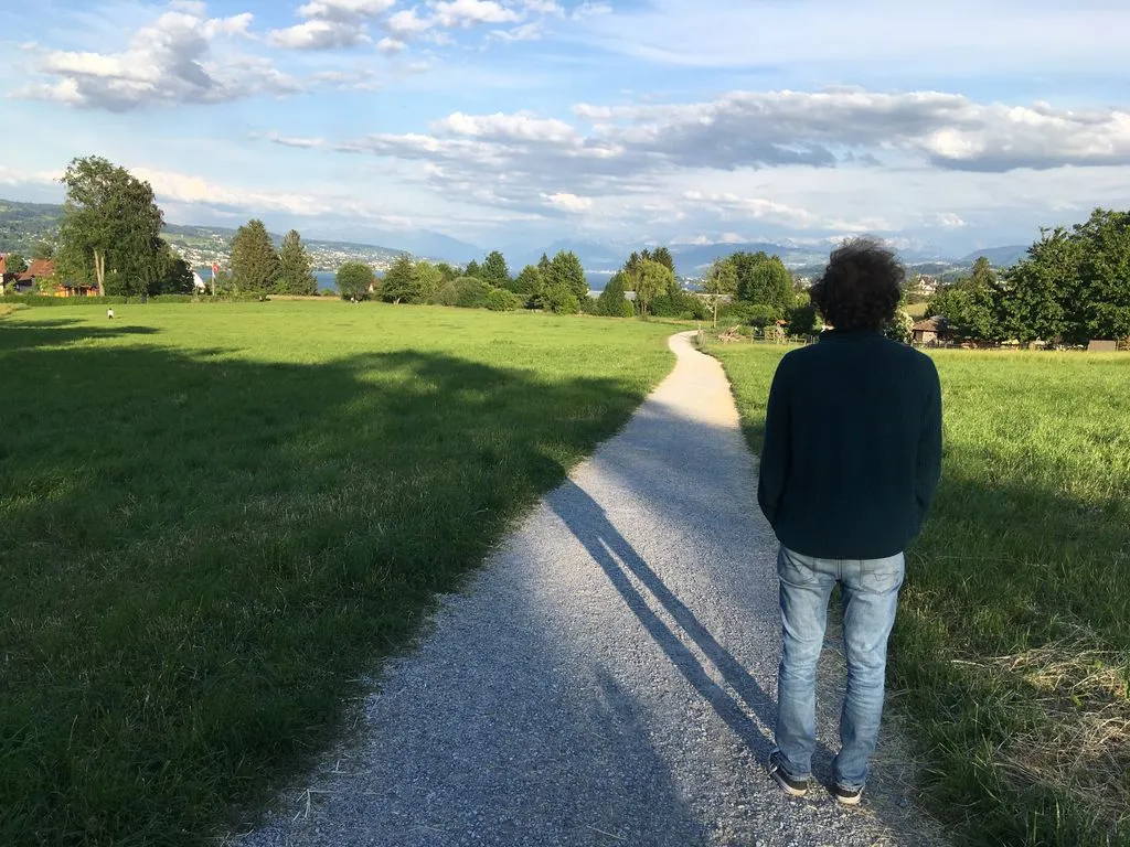 Mann auf Feldweg blickt in die Ferne