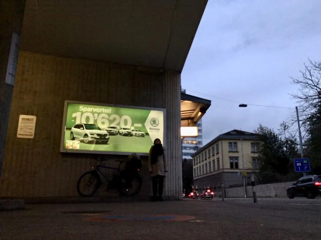 Frau vor einem grossen Werbeplakat