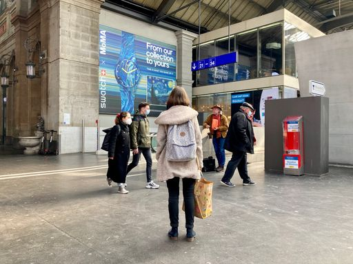 Frau steht in der Bahnhofshalle