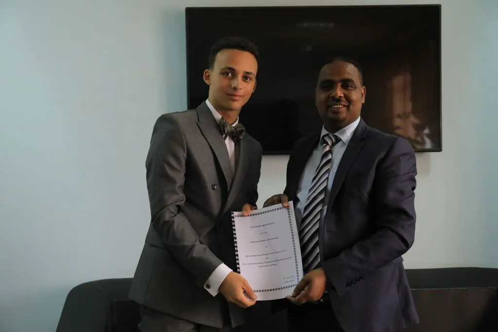 Zwei Männer zeigen gemeinsam einen Vertrag