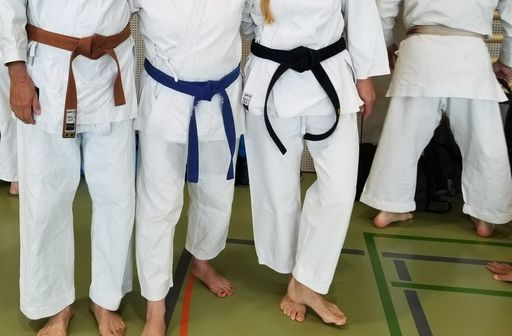 Menschen im Karate-Outfit, nur Beine sind zu sehen.
