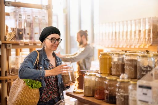 Frau mit Vorratsglas in Unverpacktpladen