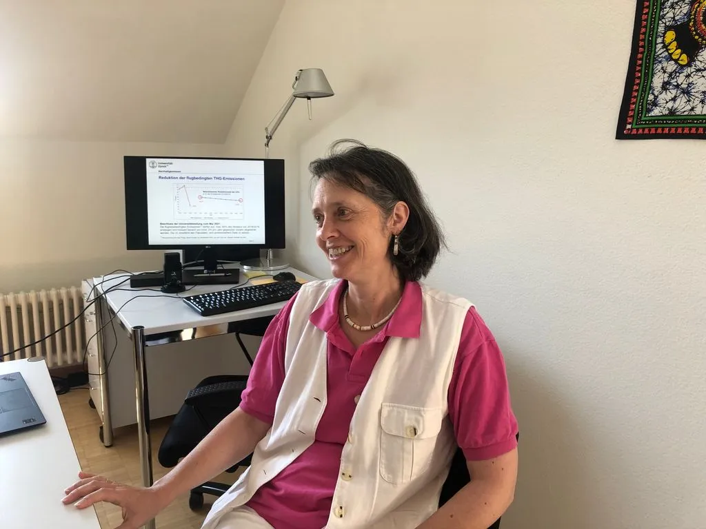 Person sitzt vor Computer mit wissenschaftlicher Grafik auf dem Bildschirm.