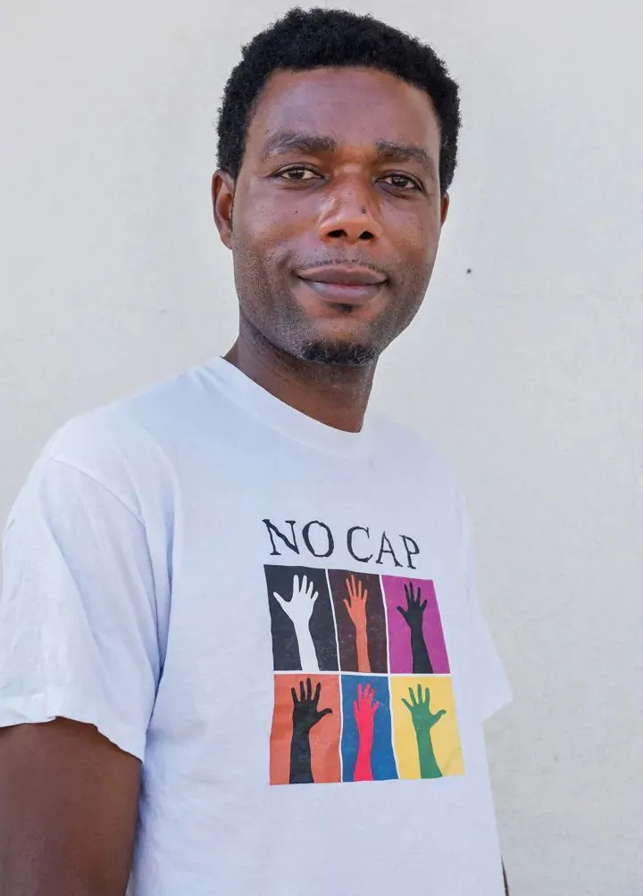 Person mit einem T-Shirt mit dem Aufdruck NO CAP.