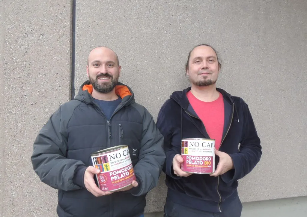 Zwei Personen halten zwei grosse Tomatenbüchsen.