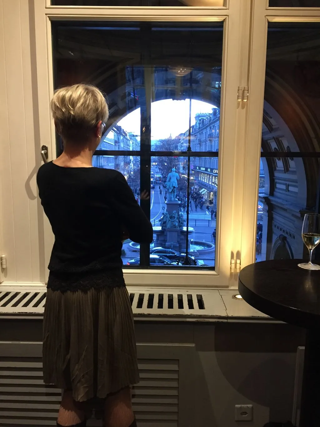 Frau schaut durch Fenster in die Ferne