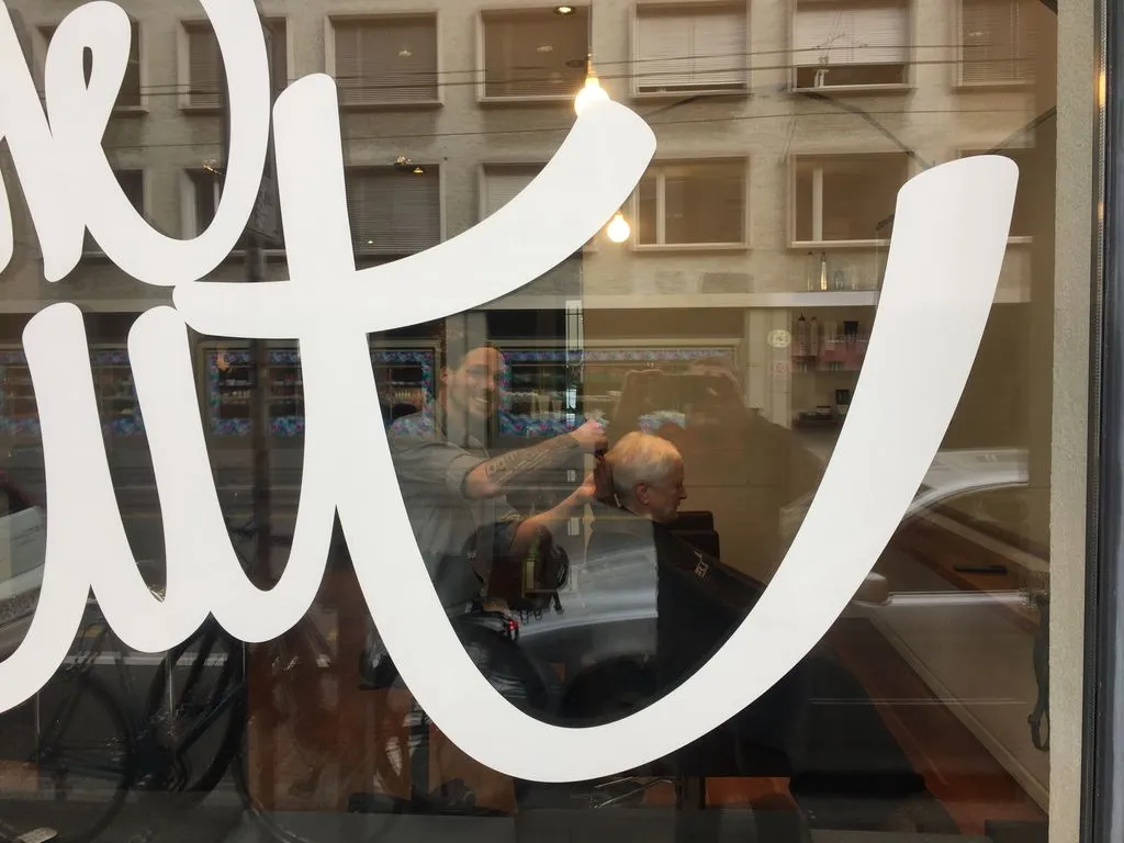 Coiffeur schneidet Haare eines Kunden