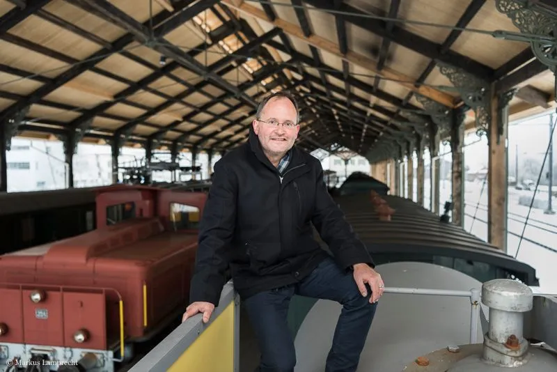 Mann sitzt auf alter Lokomotive