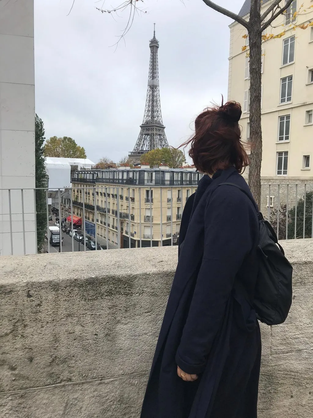 Junge Frau blickt auf Eiffelturm.