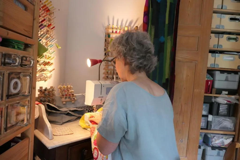 Frau sitzt an Nähmaschine