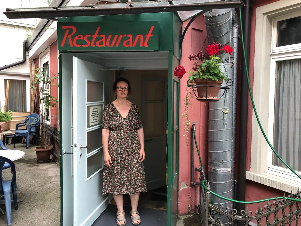 Frau steht vor Restaurant-Eingang