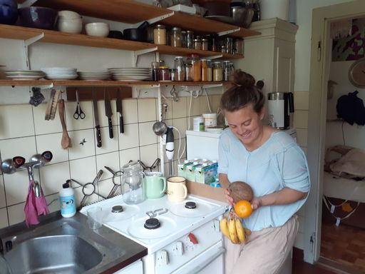 Junge Frau jongliert mit Früchten in der Küche