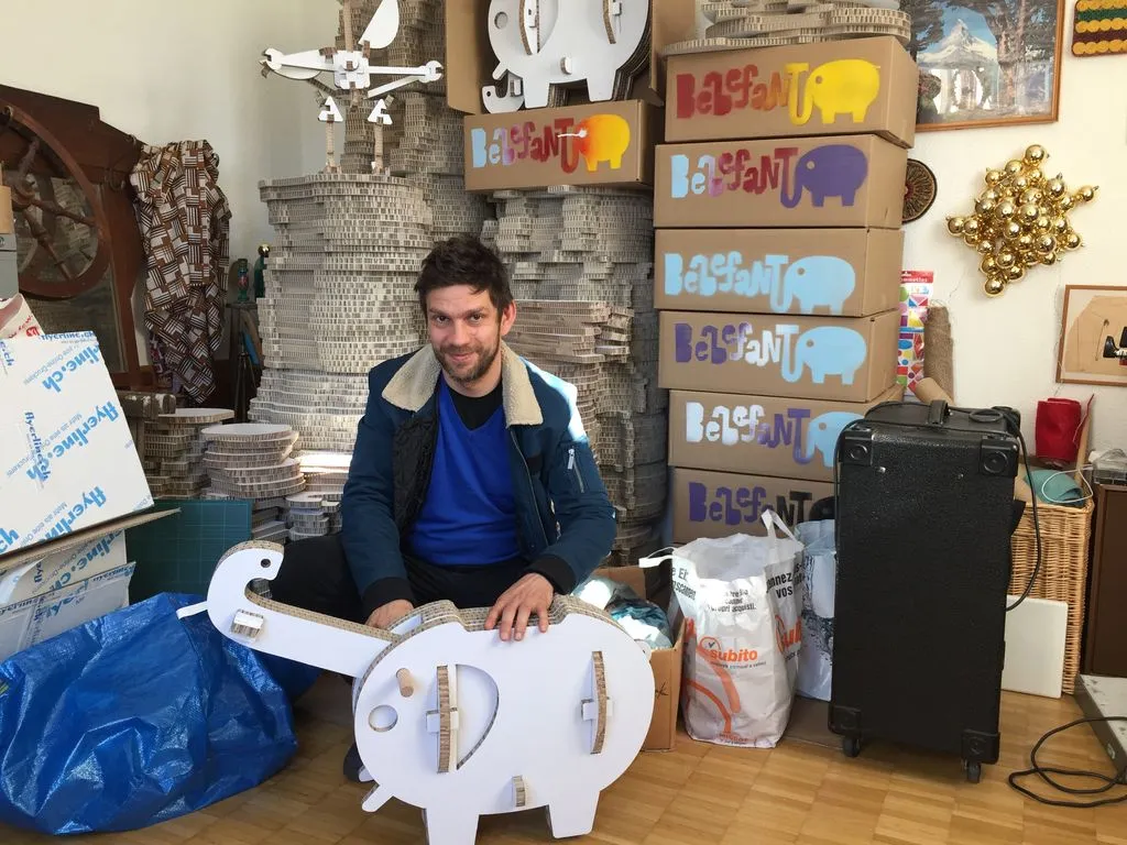 Mann hinter einem Spielzeugelephanten aus Karton