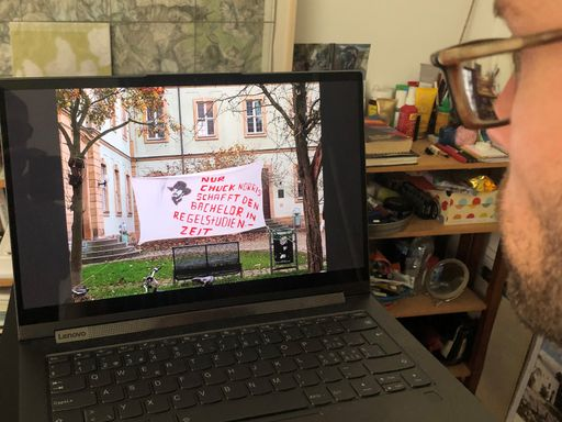 Mann schaut auf Computer Bild einer Protestaktion an.