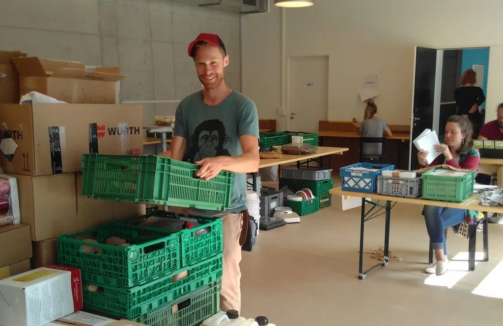 Person in einem Lagerraum mit Paletten voller Esswaren.