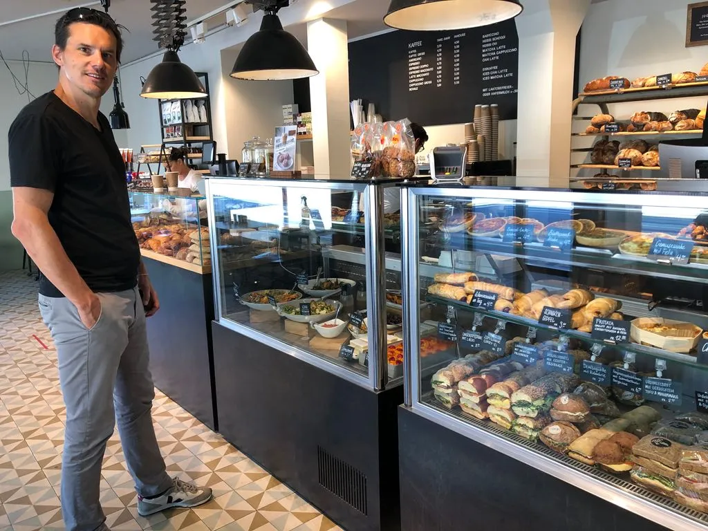 Mann steht in Bäckerei vor Theke