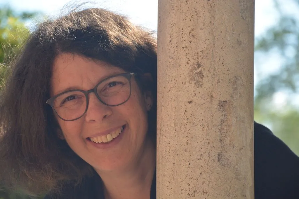 Lachende Frau mit braunen Haaren und Brille