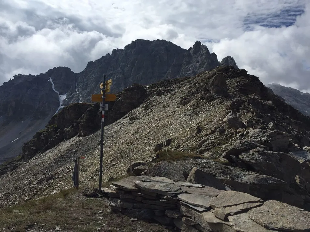 Wegweiser vor Bergpanorama.