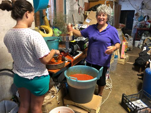 Mutter und Tochter draussen beim Einkochen von Tomatensauce