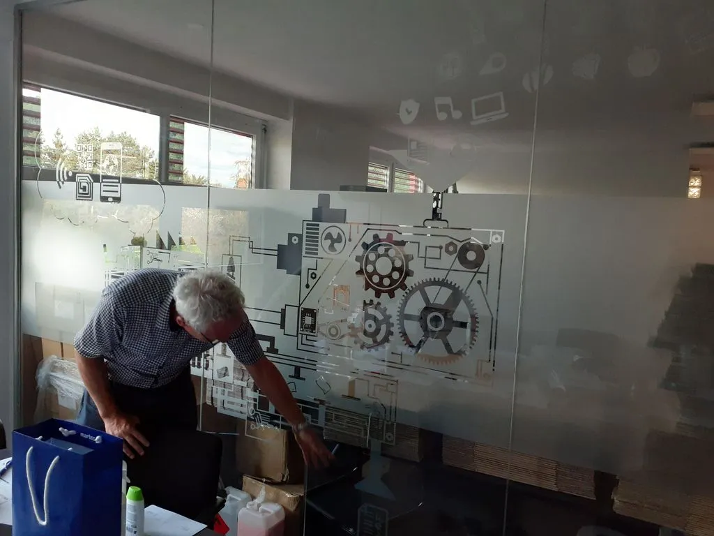 Ein Mann steht vor technischen Entwürfen an einer Wand