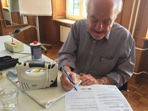 Älterer Mann unterschreibt Dokument