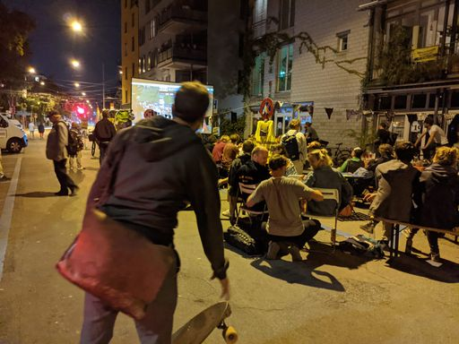 Mann mit Skateboard an Strassenfest mit Kino