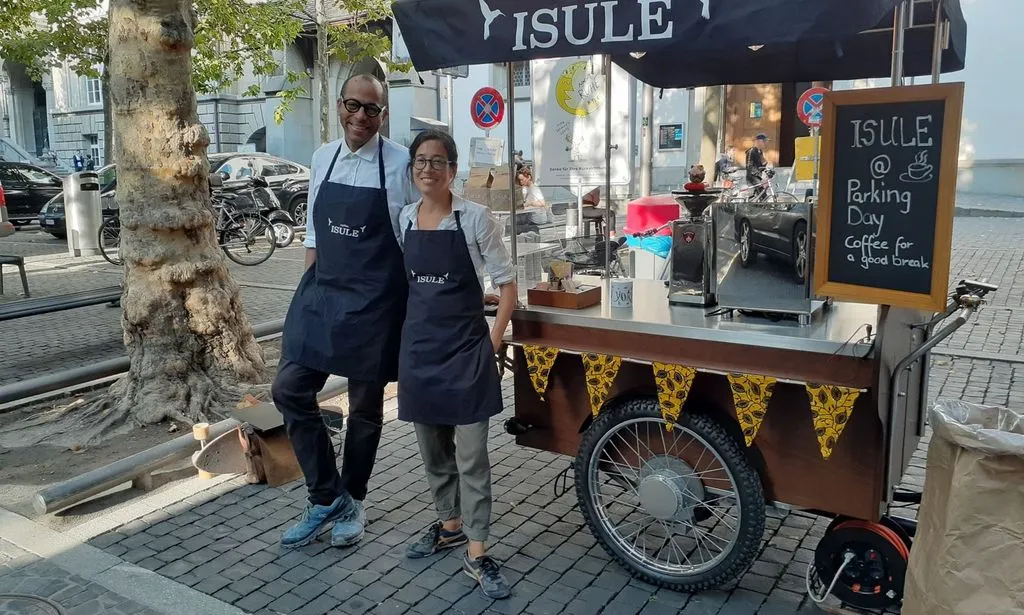 Mann und Frau vor einem Kaffeetand auf Rädern.