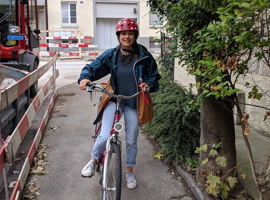 Junge Frau mit farbigem Helm auf Fahrrad.